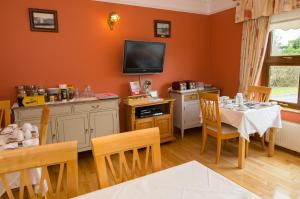 a dining room with a table and a tv at Cois Li Accommodation in Tralee