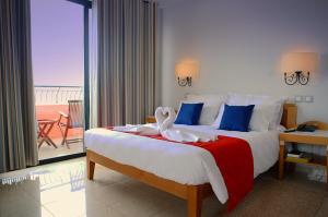 um quarto de hotel com uma cama com um cisne em Hotel Calypso em Marsalforn