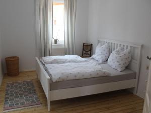 uma cama branca com lençóis e almofadas brancos num quarto em Posthof Kerstenhausen em Borken