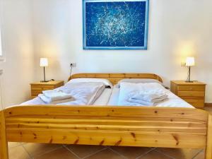 Residenza Ai Ronchi 1 2 6 في ماكانيو سوبيريور: سريرين في غرفة نوم مع مصباحين ودهان