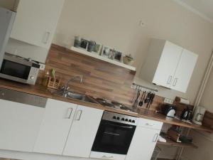 a kitchen with white cabinets and a sink and a microwave at Posthof Kerstenhausen in Borken