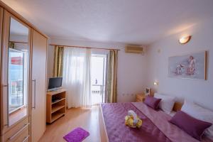 a bedroom with a purple bed and a television at Pension Maric Rooms in Brist