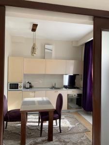 a kitchen with white cabinets and a table and chairs at PREMIUM apartments in the center of Baku in Baku