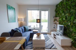 a living room with a blue couch and a green wall at Spacy Modern Apartment near Hockey Stadium in Bratislava