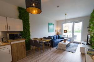 a kitchen and living room with a blue couch at Spacy Modern Apartment near Hockey Stadium in Bratislava