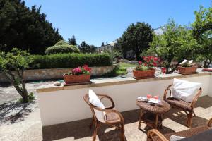 un patio con sedie e tavoli in giardino di Masseria Fagà a Otranto