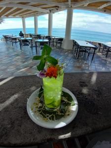 un jarrón con una flor en un plato sobre una mesa en Hotel Punta Rossa, en San Felice Circeo