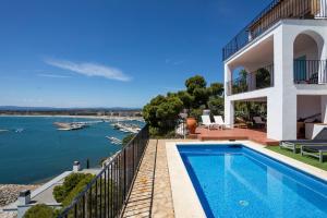 a house with a swimming pool next to the water at Casa Atalaya in L'Estartit