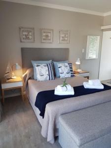a bedroom with a bed with two towels on it at Aloe @ the Sea in Mossel Bay