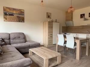uma sala de estar com um sofá e uma mesa em Apartmán Monny em Frymburk