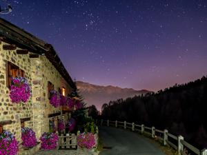 un edificio con flores al costado de él por la noche en Baita Luleta en Livigno