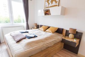 a bed in a room with a large window at Spacy Modern Apartment near Hockey Stadium in Bratislava