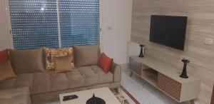 a living room with a couch and a table at Superb & Modern apartment at Berges Lac 2 close to Tunisia Mall in Tunis