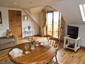 uma sala de estar com uma mesa de madeira e uma televisão em Rhiastyn Barn em Hyssington