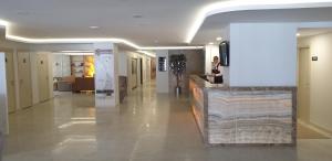 a hallway of a building with a woman sitting at a counter at Marti Beach Hotel in Kuşadası