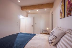 a bedroom with white walls and a bed with a blue blanket at Haus Haag in Achenkirch