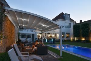 a group of people sitting under a pergola by a pool at Casa Romantico in Bruges