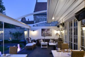 une terrasse avec des canapés, des tables et des chaises dans l'établissement Casa Romantico, à Bruges