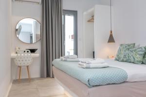 a bedroom with a bed with a mirror and a chair at Korali Palace Hotel in Naxos Chora