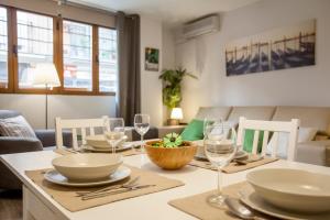 una sala da pranzo con tavolo, piatti e bicchieri da vino di Apartamento Alta a Valencia