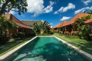 a swimming pool in the yard of a house at Orora Bungalows in Canggu