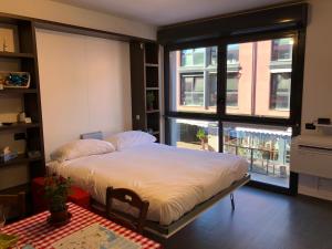 a bedroom with a bed and a large window at l’Ancora luxury apartment in Genova