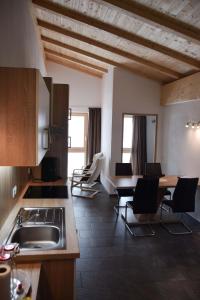 cocina con sillas, fregadero y mesa en Naglerhof en Curon Venosta
