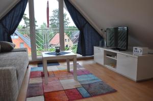 a living room with a tv and a coffee table at Ferienhaus Müritzzauber / 1 Zimmer Dachgeschoss-Appartement in Röbel