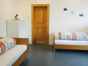 um quarto com 2 camas e uma porta de madeira em Apartment Silbertal - Ferienwohnung em Silbertal