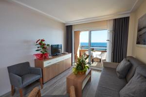 salon z kanapą i telewizorem w obiekcie Les Dunes Suites w mieście Benidorm