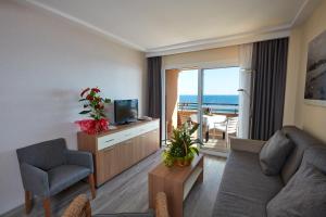 a living room with a couch and a television at Les Dunes Suites in Benidorm