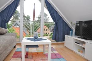 a living room with a white coffee table and a large window at Ferienhaus Müritzzauber / 1 Zimmer Dachgeschoss-Appartement in Röbel