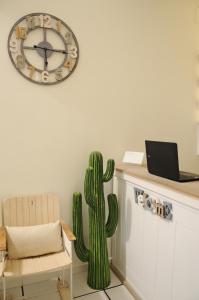 una habitación con un cactus y un reloj en la pared en Thalìa Guest House Marzamemi, en Marzamemi