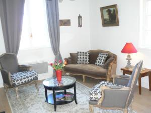 a living room with a couch and chairs and a table at Petite Maison Romantique au calme, Cœur Historique, vue Ville et Jardin in Le Mans