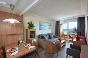 salon ze stołem oraz salon z kanapą w obiekcie Les Dunes Suites w mieście Benidorm