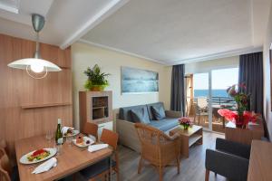 a living room with a table and a living room with a couch at Les Dunes Suites in Benidorm