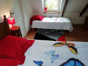 BégardにあるLa Peupleraieのベッドルーム1室(ベッド2台、蝶のシーツ付きのベッド1台付)