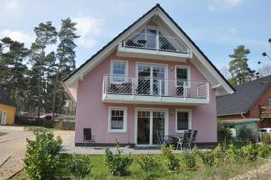 a pink house with a gambrel roof at Ferienhaus Müritzzauber / EG-Appartement in Marienfelde