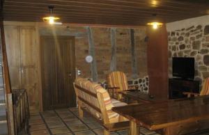 uma sala de estar com uma mesa de madeira e cadeiras em La Botería em Salas de los Infantes
