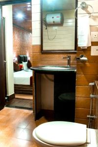 ein Bad mit einem Waschbecken, einem WC und einem Bett in der Unterkunft Tin Tin Boutique Bijanbari in Darjeeling