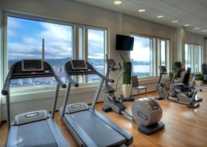 a gym with several tread machines in a room with windows at Solo Sokos Hotel Paviljonki in Jyväskylä