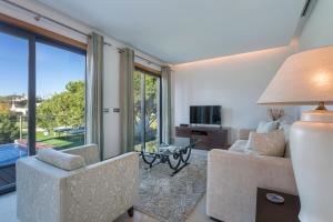 a living room with a couch and chairs and a television at Alexandra in Vale do Lobo