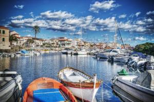 a group of boats docked in a marina with houses at 103 Boutique Hotel Stintino in Stintino