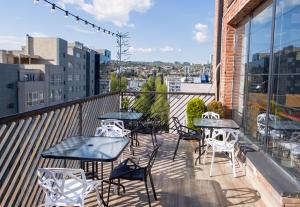 un patio con mesas y sillas en el balcón en Boutique Hotel, en Tiflis