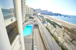 a balcony of a building with a view of the beach at Appartement bord de mer Biarritz in Biarritz