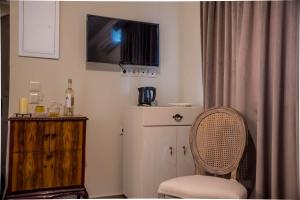 Pokój z krzesłem i telewizorem na ścianie w obiekcie Kyria Boutique House w Atenach +37 zdjęć