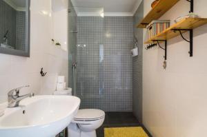 a bathroom with a sink and a toilet and a shower at Casas do Bárrio in Alcobaça +39 photos
