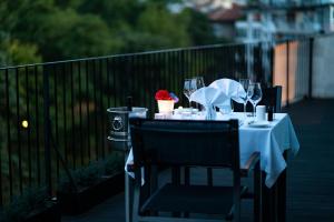 a table with chairs and wine glasses on a balcony at mOdus Hotel in Varna City