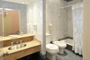 a bathroom with a sink and a toilet and a tub at Hotel Muñiz in Bahía Blanca +43 photos