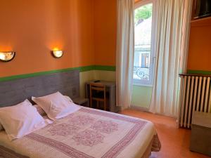 a bedroom with a bed and a large window at Hotel des voyageurs Chez Betty in Neussargues-Moissac